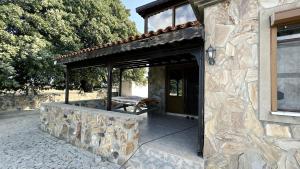 a stone building with a covered porch with a bench at Bozcaada Bag Evi in Bozcaada