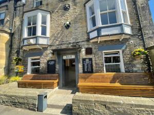a building with wooden benches in front of it at Crown & Crossed Swords in Shotley Bridge