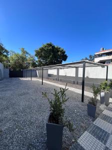 a parking lot with potted plants and a fence at Aparts Magallanes in Pilar