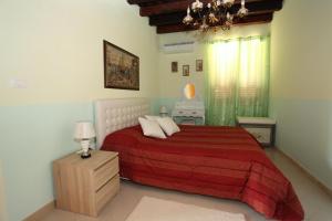 a bedroom with a large bed with a red blanket at Villa Salvatore in San Leone