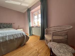 a bedroom with a bed and a chair and a window at Chiemgauer Landliebe in Höslwang