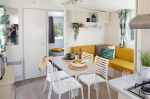 a kitchen and living room with a table and chairs at Sun Sea camping le Bosc in Saint-Cyprien
