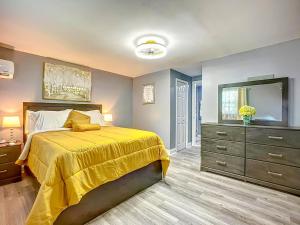 a bedroom with a yellow bed and a dresser at Private Guest House 10 Min to Airport & Downtown in Jacksonville