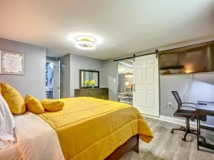 a bedroom with a yellow bed and a desk at Private Guest House 10 Min to Airport & Downtown in Jacksonville