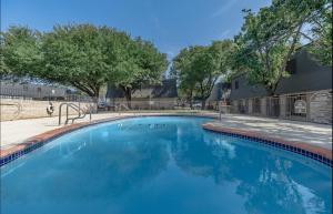 a large blue swimming pool with trees in the background at Modern 2BR townhome with full kitchen & dining in Arlington