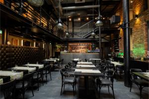 a restaurant with tables and chairs and a bar at Best Western Hotel Mariacki Katowice in Katowice