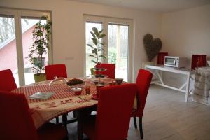 a dining room with a table and red chairs at Chambres d'hôtes Souffle Nature in Montenois