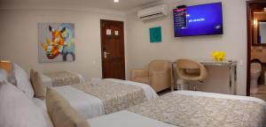 a hospital room with two beds and a tv on the wall at Hotel Windsor Barranquilla in Barranquilla