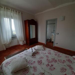 a bedroom with a large bed with a floral bedspread at Casa Girella in Terontola