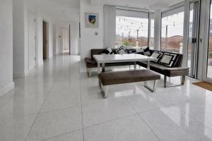 a living room with a couch and a table and chairs at Skyline Luxury Penthouse Belfast City Centre in Belfast