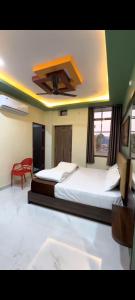 a bedroom with two beds and a ceiling at Hotel kanha Royal Inn in Jodhpur
