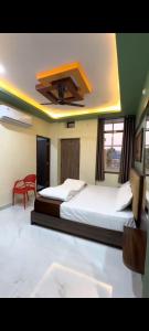 a bedroom with two beds and a ceiling fan at Hotel kanha Royal Inn in Jodhpur