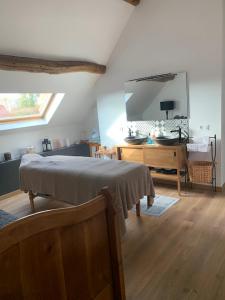 a bedroom with a bed and a dresser and a mirror at Le relais de poste Valero in Serazereux +13 photos