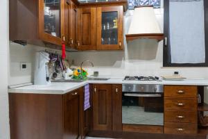 a kitchen with wooden cabinets and a stove top oven at Casa Vacanze Chiara in Terni