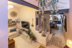 a living room with a couch and a clock on the wall at Elegant Maltese Townhouse in Attard