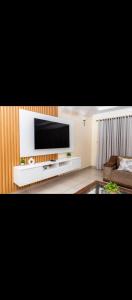 a living room with a flat screen tv on a white entertainment center at Cozy Corner Monavale in Harare +12 photos