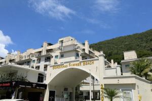 a white building with a sign that reads upcoming summer beach at 131 - Bombas Summer Beach depto 1 dormitorio para 4 con amenities in Bombinhas