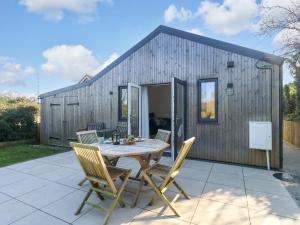 a small shed with a table and chairs on a patio at The Pebble in Dorchester
