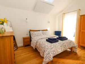 a bedroom with a bed with two blue towels on it at The Pebble in Dorchester