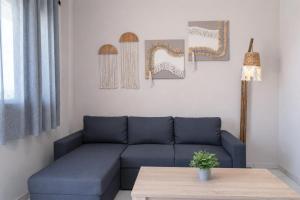 a living room with a blue couch and a table at GreKa apartments in Kalives Poligirou