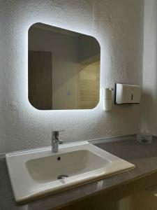 a bathroom sink with a mirror on a counter at Alexandra Apartment in Agíasma