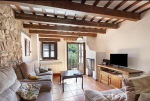 a living room with a couch and a tv at Cal Vidal in Mura