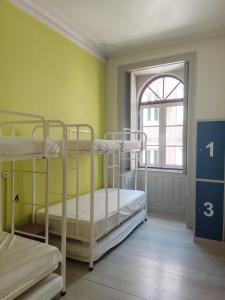 a room with two bunk beds and a window at Meeting Hostel in Figueira da Foz