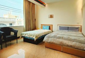 a bedroom with two beds and a large window at 佳家民宿 in Linbian