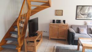 a living room with a tv and a staircase at Kaptains Koje in Wittmund