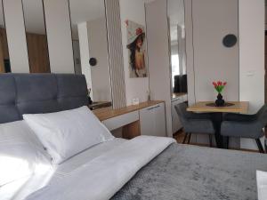 a bedroom with a bed and a desk and a table at Studio Sky in Smederevo