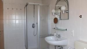 a white bathroom with a shower and a sink at Kaptains Koje in Wittmund +12 photos