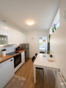 a kitchen with a white table and a white counter top at Studio cosy avec parking, tram direct Strasbourg 7 min in Illkirch-Graffenstaden