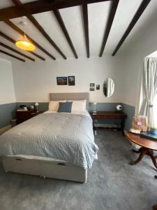 a bedroom with a bed and a table at Stone's Throw Guest House in Weymouth