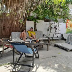 a man and a boy sitting on a couch with a table at Hostel Nugeku in Rincón +37 photos