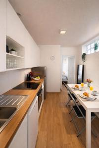 a kitchen with a counter and a table with chairs at Studio cosy avec parking, tram direct Strasbourg 7 min in Illkirch-Graffenstaden +12 photos