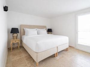 a bedroom with a white bed and a window at Sara in Les Issambres +11 photos