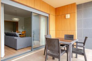 a dining room with a table and chairs and a couch at BeGuest Olhão Ria Formosa View in Olhão