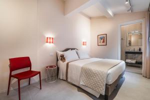 a bedroom with a bed and a red chair at Palazzo Accademia in Florence
