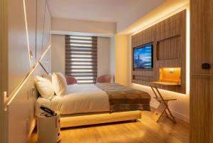 ein Schlafzimmer mit Bett, Schreibtisch und Fenster in der Unterkunft Hotel Nodo - El primer hotel de negocios en Chile in Santiago + 48 Fotos