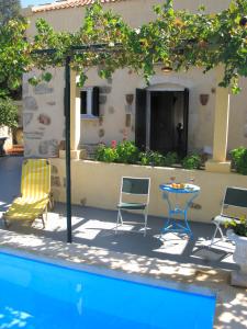 a patio with chairs and a table next to a pool at Stathis Villa in Vamos