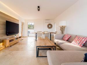 a living room with a couch and a flat screen tv at Sara in Les Issambres