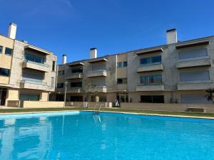 a large swimming pool in front of a building at Ofir Beach Apartment in Fão