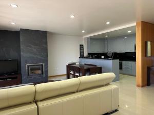 a living room with a white couch and a kitchen at Ofir Beach Apartment in Fão