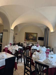 a dining room with white tables and chairs and a painting at Villa Altieri in Albano Laziale