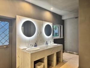 a bathroom with two sinks and two mirrors at Villa Altieri in Albano Laziale