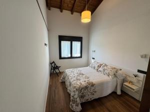 a bedroom with a bed and a window at APARTAMENTOS LOS MANZANOS in Ribadesella