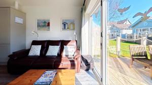 a living room with a couch and a sliding glass door at Puffin Lodge - Part of the The Bay Filey Holiday Village with pool, gym and direct beach access, pub, restaurant, tennis and meadows walks in Filey