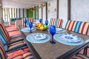 a table with blue glasses and a bowl of fruit at Family Country Retreat w Pool, Games & Fire Pit in Clewiston
