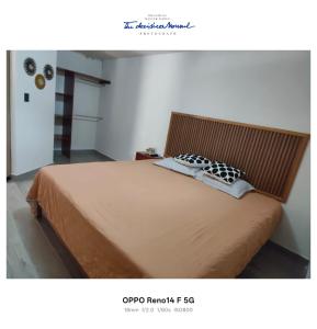 a bedroom with a large bed with a wooden headboard at Casa tierno amanecer in Xpujil