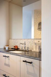 a kitchen with white cabinets and a sink at De Zonnebrug in Sint-Laureins +36 photos